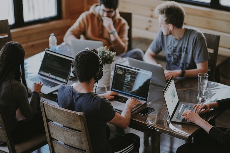 Equipo pequeño de empresa colaborando con herramientas digitales en una reunión de trabajo