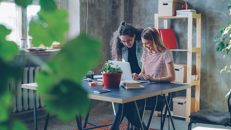 Dos profesionales revisando juntas la reorganización de tareas con inteligencia artificial en la empresa